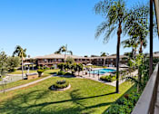 Thumbnail 1 of 28 - A view of a pool and a building from a balcony.
