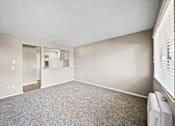Thumbnail 22 of 28 - A room with a carpeted floor and a window with blinds.