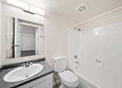 Thumbnail 14 of 18 - A bathroom with a toilet, sink, and bathtub.