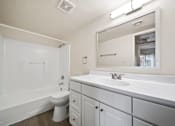 Thumbnail 8 of 18 - A white bathroom with a toilet, sink, and bathtub.