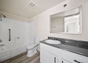 Thumbnail 17 of 18 - A white bathroom with a toilet, sink, and mirror.