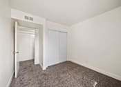 Thumbnail 11 of 18 - A room with a carpeted floor and a white door.