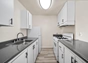 Thumbnail 13 of 18 - A kitchen with white cabinets and a stove top oven.