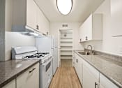 Thumbnail 15 of 18 - A kitchen with a white stove and cabinets.