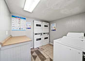 Thumbnail 10 of 18 - A small kitchen with white appliances and a wooden counter.