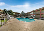 Thumbnail 2 of 18 - A pool in a courtyard surrounded by a fence.