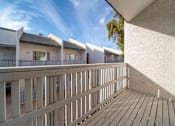 Thumbnail 7 of 18 - A balcony with wooden slats and a white wall.