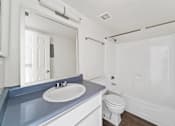 Thumbnail 18 of 18 - A white bathroom with a blue counter top.