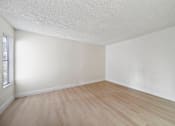 Thumbnail 12 of 18 - A room with wooden flooring and white walls.