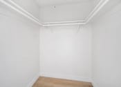 Thumbnail 17 of 18 - A white room with a wooden floor and white walls.