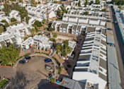 Thumbnail 1 of 18 - A parking lot with cars and a building in the background.