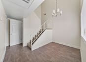 Thumbnail 13 of 18 - A room with a staircase and a chandelier.
