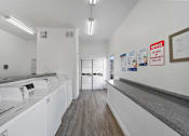 Thumbnail 11 of 18 - A laundromat with washers and dryers and a notice on the wall.