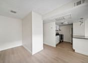 Thumbnail 15 of 18 - A kitchen area with white walls and wooden flooring.