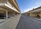 Thumbnail 5 of 5 - A long, narrow street with cars parked on both sides.