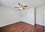 Thumbnail 6 of 12 - A room with a ceiling fan and wood flooring.