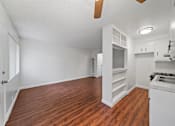 Thumbnail 5 of 12 - A kitchen with white cabinets and a wooden floor.