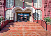Thumbnail 3 of 12 - A red brick walkway leads to a building entrance.