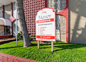 Thumbnail 1 of 12 - A sign for the Maror Apartments is displayed in front of a building.
