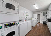 Thumbnail 2 of 12 - A laundry room with washing machines and a dryer.