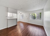 Thumbnail 10 of 12 - A room with wooden floors and white walls.