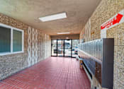 Thumbnail 4 of 12 - A hallway with a red brick floor and a Manager's Office sign on the wall.
