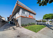 Thumbnail 1 of 4 - A modern house with a grey and orange exterior and a blue door.