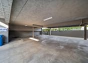 Thumbnail 2 of 4 - A large, empty, concrete-floored room with a concrete ceiling and walls.