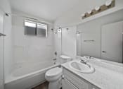 Thumbnail 10 of 10 - A white bathroom with a toilet, sink, and bathtub.