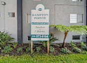 Thumbnail 2 of 10 - A sign for Hampton Pointe Apartments is in front of a building.