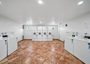 Thumbnail 8 of 10 - A laundry room with washing machines and dryers.