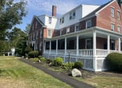 Thumbnail 57 of 58 - a large brick house with a white porch and a white
