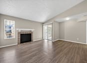 Thumbnail 9 of 15 - A living room with a fireplace and sliding glass doors at Logans Mill, Austin, TX.
