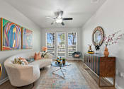 Thumbnail 13 of 19 - A living room with a white couch, a coffee table, and a ceiling fan at The Atlantic Highland Park, Texas, 75209