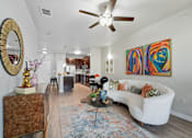 Thumbnail 12 of 19 - A living room with a white couch and a colorful painting on the wall at The Atlantic Highland Park, Texas, 75209