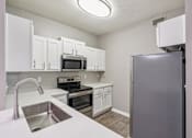 Thumbnail 9 of 27 - A kitchen with white cabinets and a stainless steel refrigerator at The Atlantic Canton Ridge, Georgia