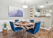 Thumbnail 3 of 24 - A dining room with a table set for two and a large abstract painting on the wall.
