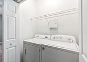 Thumbnail 14 of 27 - A white washer and dryer in a small laundry room at The Atlantic Canton Ridge, Georgia