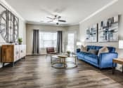 Thumbnail 19 of 25 - a living room with a blue couch and a coffee table at Village of Hawks Creek Apartments, Texas