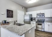 Thumbnail 7 of 25 - a kitchen with granite counter tops and stainless steel appliances at Village of Hawks Creek Apartments, Westworth Village, TX 76114