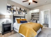 Thumbnail 9 of 25 - a bedroom with a bed and a ceiling fan at Village of Hawks Creek Apartments, Westworth Village, 76114