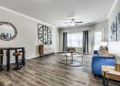 Thumbnail 18 of 25 - a living room with a large clock on the wall at Village of Hawks Creek Apartments, Westworth Village