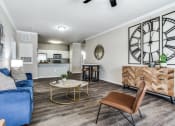 Thumbnail 17 of 25 - a living room with a large clock on the wall and a couch at Village of Hawks Creek Apartments, Westworth Village Texas