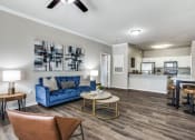 Thumbnail 16 of 25 - a living room with a blue couch and a table at Village of Hawks Creek Apartments, Westworth Village, 76114
