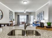 Thumbnail 20 of 25 - a kitchen with a sink and a view of a living room at Village of Hawks Creek Apartments, Texas, 76114