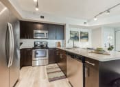 Thumbnail 2 of 18 - Open kitchen with stainless steel appliances and a counter top at The Atlantic at Tradition, Port St Lucie, Florida