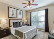 Thumbnail 14 of 17 - Bedroom with ceiling fan and large window at Vintage Park Apartments, Houston, TX