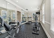 Thumbnail 13 of 24 - A spacious home gym with a variety of exercise equipment.