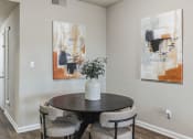 Thumbnail 3 of 14 - a dining room with paintings on the wall and a table with chairs  at Harrison Grande, Cary, NC, 27513