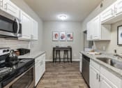 Thumbnail 1 of 14 - a spacious kitchen with white cabinets and granite counter tops  at Harrison Grande, Cary, 27513